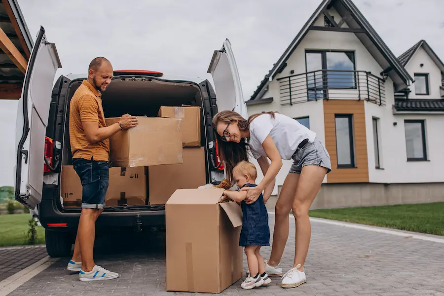 molodaa-sem-a-s-malen-koi-dockoi-pereezzaet-v-novyi-dom Die Familie lädt die verpackten Möbel und Gegenstände für den Transport und Umzug in den Kleinbus.