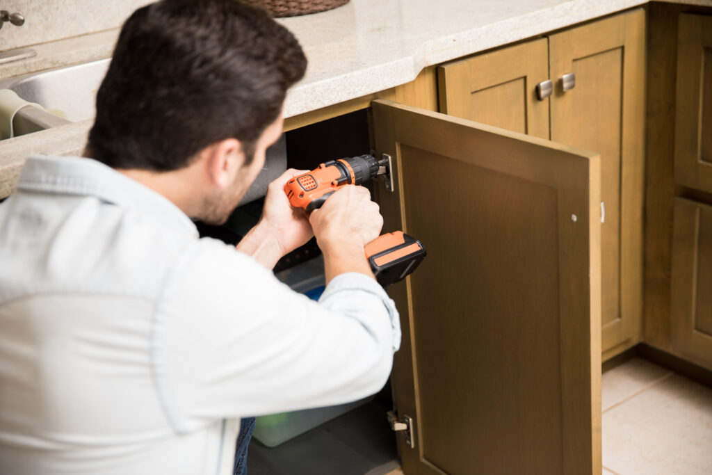 Handyman fixing a kitchen cabinet